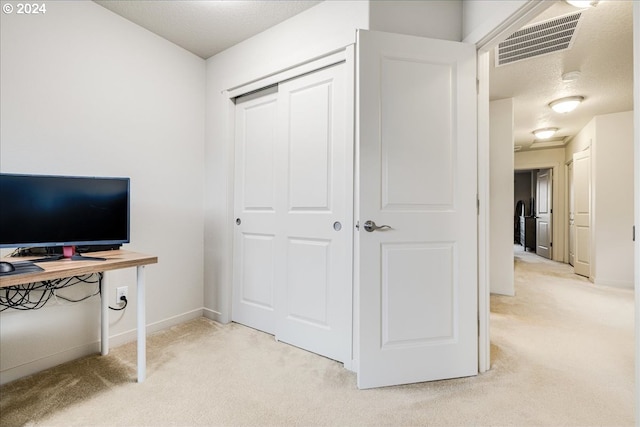 carpeted office with a textured ceiling