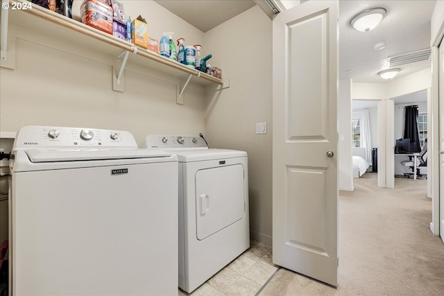 clothes washing area with light colored carpet and washing machine and clothes dryer