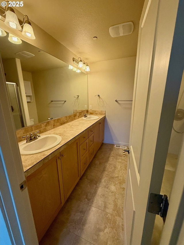 bathroom with a textured ceiling and vanity