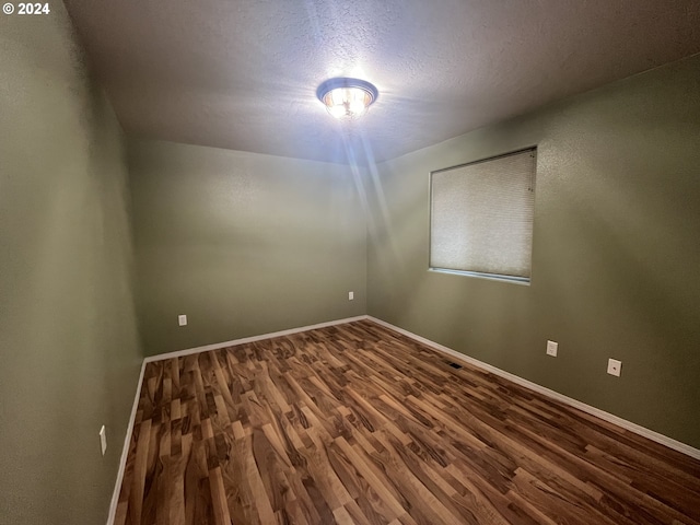 spare room featuring a textured ceiling and hardwood / wood-style flooring