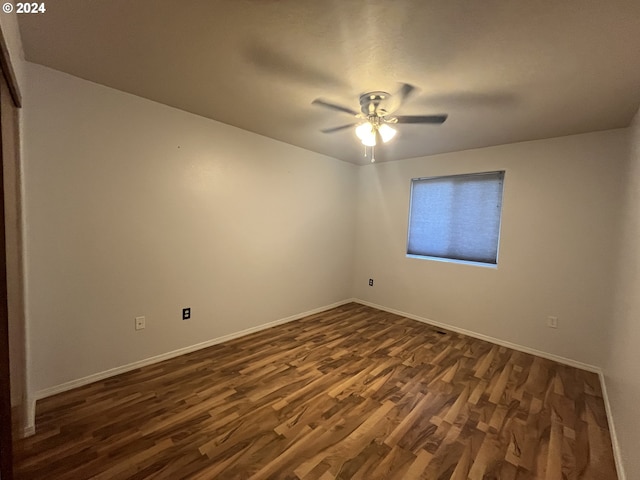 empty room with dark hardwood / wood-style flooring and ceiling fan