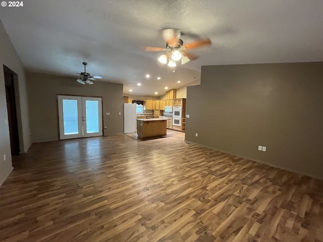 unfurnished living room featuring lofted ceiling, ceiling fan, french doors, and dark hardwood / wood-style flooring