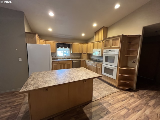 kitchen with vaulted ceiling, white appliances, a kitchen island, light hardwood / wood-style flooring, and sink