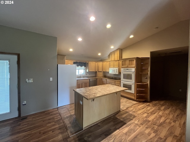 kitchen featuring lofted ceiling, white appliances, a center island, and sink