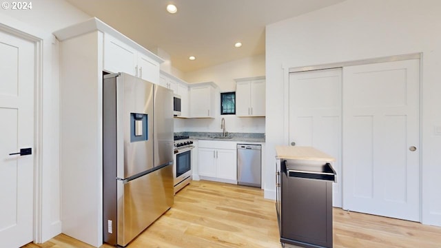 94256 11th St, Gold Beach, OR 97444 - kitchen with stainless steel appliances, a sink, white cabinets, light wood-style flooring, and recessed lighting