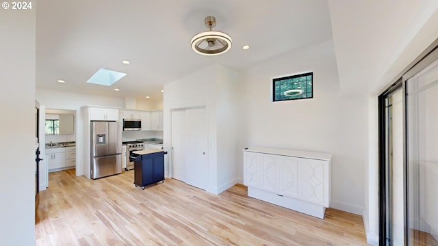 94256 11th St, Gold Beach, OR 97444 - kitchen featuring stainless steel appliances, a skylight, white cabinets, light countertops, and light wood-style floors