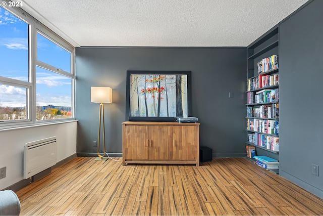 unfurnished room with a textured ceiling and light hardwood / wood-style floors