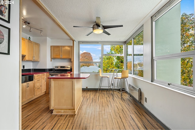 kitchen with light hardwood / wood-style floors, a textured ceiling, sink, ceiling fan, and electric range