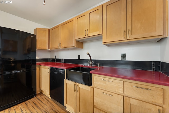 1220 NE 17th Ave Unit 4C, Portland, OR 97232 - kitchen with black appliances, a sink, light wood finished floors, dark countertops, and light brown cabinetry