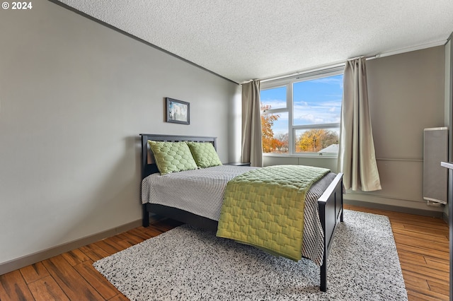 1220 NE 17th Ave Unit 4C, Portland, OR 97232 - bedroom with baseboards, a textured ceiling, crown molding, and wood finished floors
