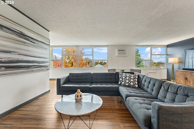 living room with a textured ceiling, an AC wall unit, and hardwood / wood-style flooring