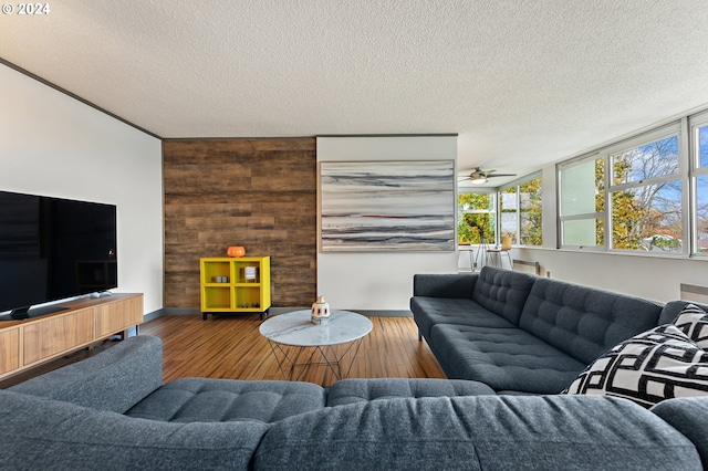 1220 NE 17th Ave Unit 4C, Portland, OR 97232 - living room with wood finished floors, a textured ceiling, baseboards, and ceiling fan