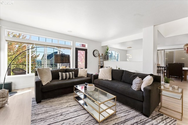 living room with light hardwood / wood-style floors and an inviting chandelier