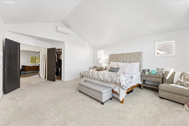 bedroom featuring light colored carpet, lofted ceiling, multiple windows, and a walk in closet