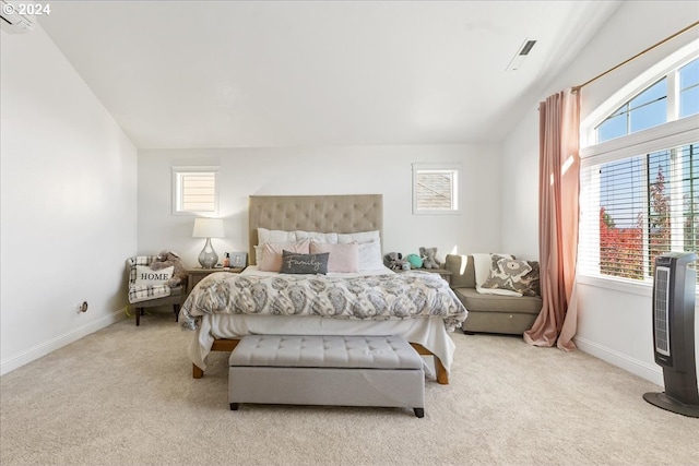 bedroom featuring light carpet, heating unit, and vaulted ceiling