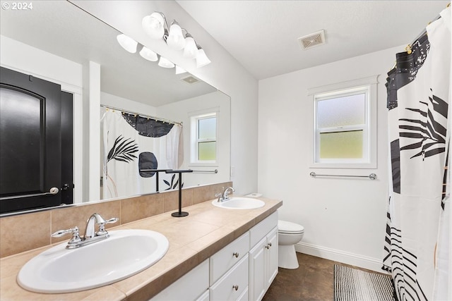 bathroom with walk in shower, vanity, toilet, and tile patterned floors