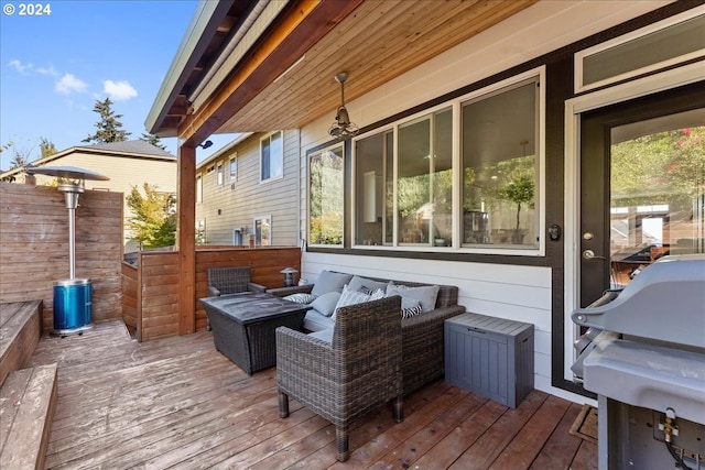 wooden terrace with area for grilling and an outdoor living space