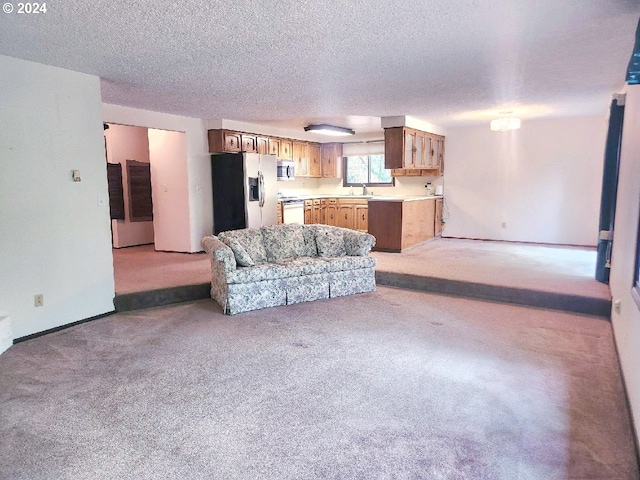 carpeted living room with a textured ceiling and sink