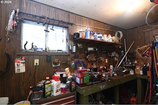 misc room with a workshop area and wood walls