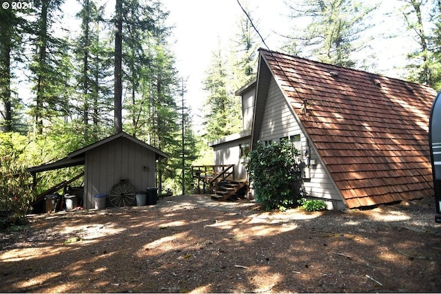 view of property exterior with a storage unit