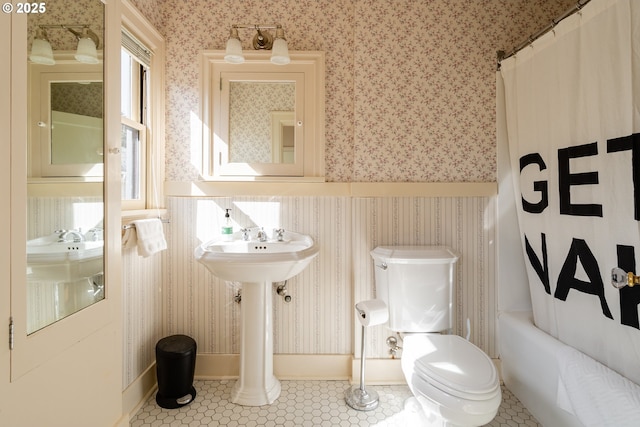 bathroom with shower / bathtub combination with curtain, tile patterned floors, and toilet