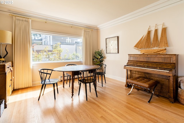 dining space featuring ornamental molding and light hardwood / wood-style floors