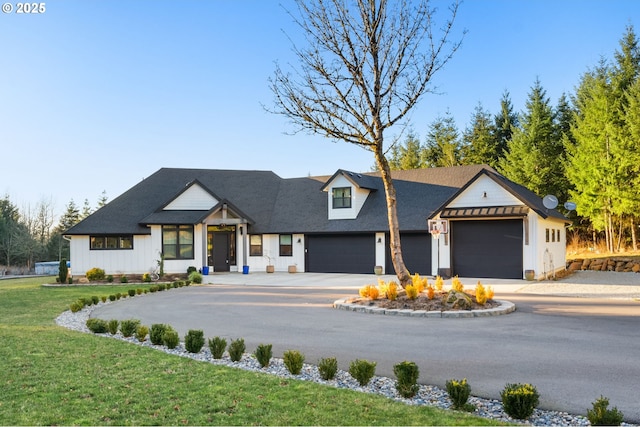 modern inspired farmhouse featuring a garage, a front yard, and driveway