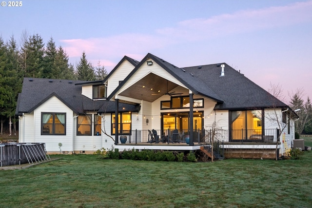 rear view of house featuring a yard, a shingled roof, a ceiling fan, crawl space, and cooling unit