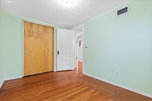 unfurnished bedroom featuring hardwood / wood-style floors and a closet