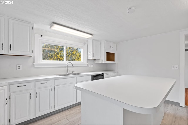 kitchen with light hardwood / wood-style flooring, sink, a center island, white cabinetry, and dishwasher