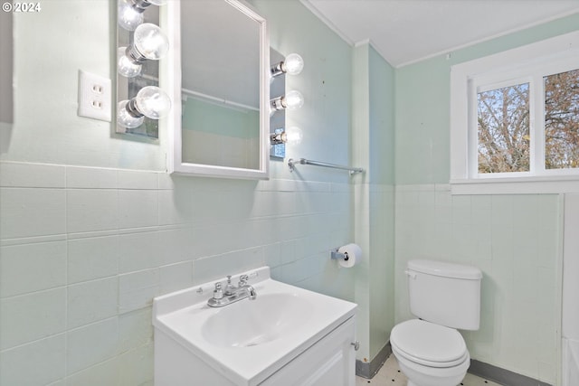 bathroom with tile walls, vanity, and toilet