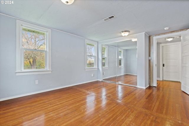 empty room featuring a wealth of natural light and hardwood / wood-style floors