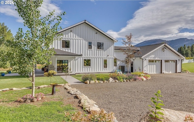 modern farmhouse style home featuring a mountain view, a front lawn, and a garage