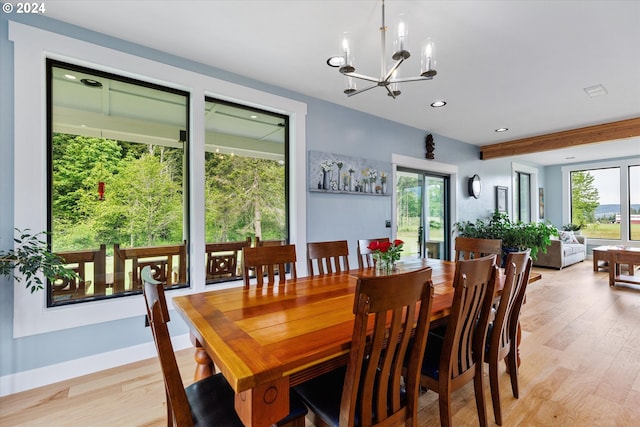 dining space featuring a chandelier, a healthy amount of sunlight, and light hardwood / wood-style flooring