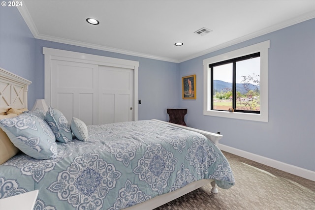 bedroom with a mountain view, carpet floors, crown molding, and a closet