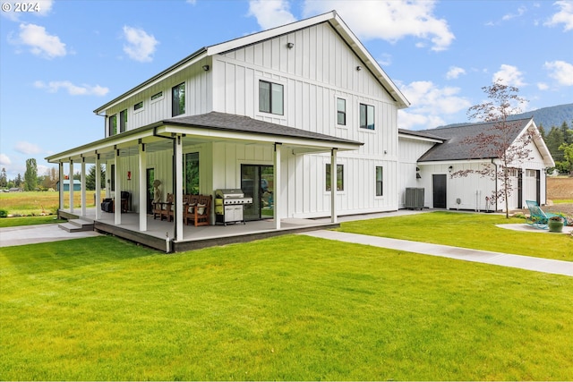 rear view of property featuring cooling unit and a lawn