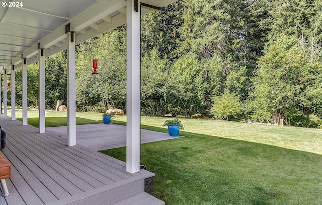 wooden terrace featuring a lawn and a patio area