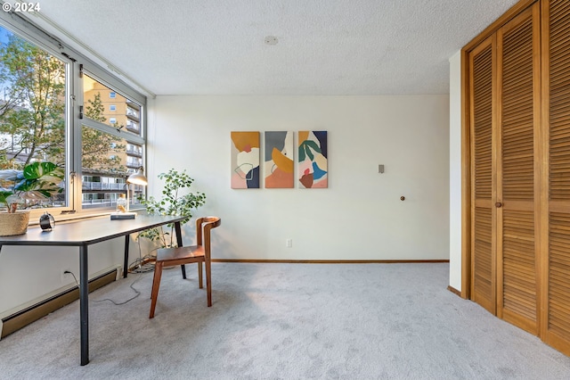 carpeted office with a textured ceiling and a baseboard heating unit