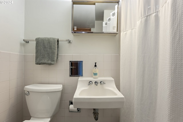 bathroom with toilet and tile walls