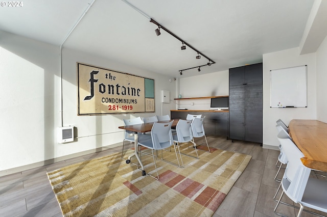 dining space with light hardwood / wood-style flooring, heating unit, and track lighting