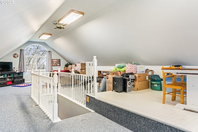 interior space featuring vaulted ceiling and carpet