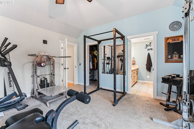 exercise area with vaulted ceiling and light colored carpet