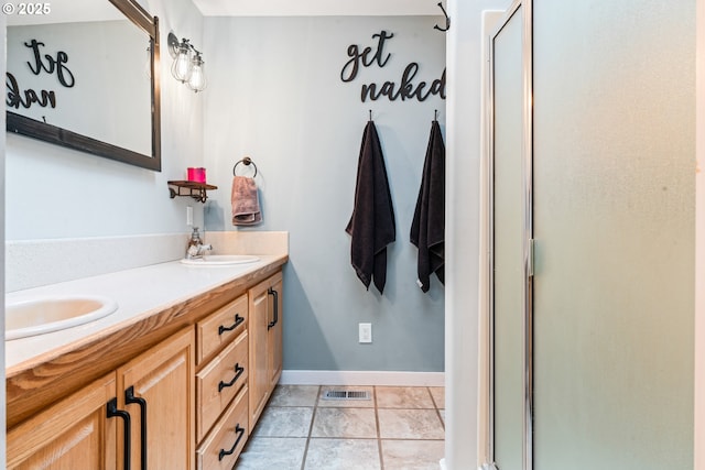 bathroom with vanity, walk in shower, and tile patterned floors