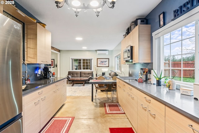 kitchen featuring sink, a wall mounted AC, light brown cabinetry, and appliances with stainless steel finishes