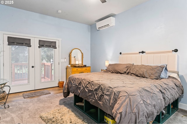 bedroom with hardwood / wood-style floors, french doors, access to exterior, a wall mounted AC, and ceiling fan