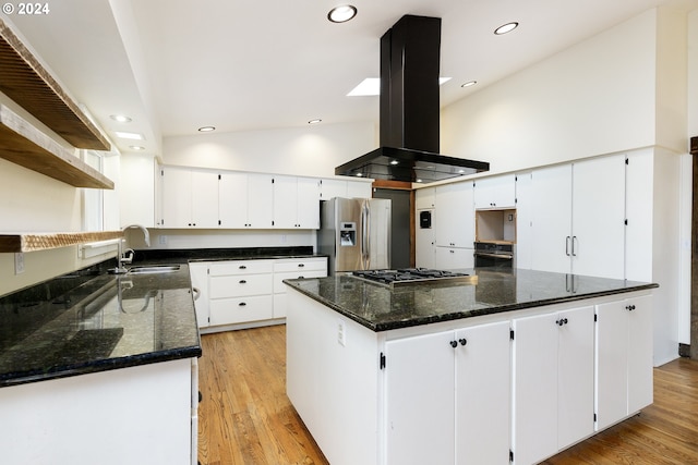 kitchen featuring stainless steel appliances, vaulted ceiling, white cabinetry, and island range hood