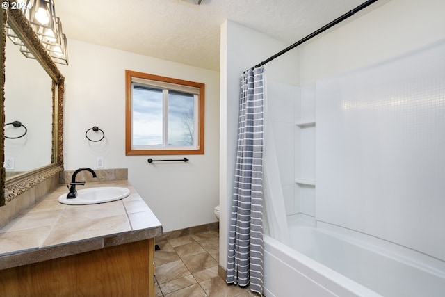 full bathroom with vanity, shower / bath combo, tile patterned floors, toilet, and a textured ceiling