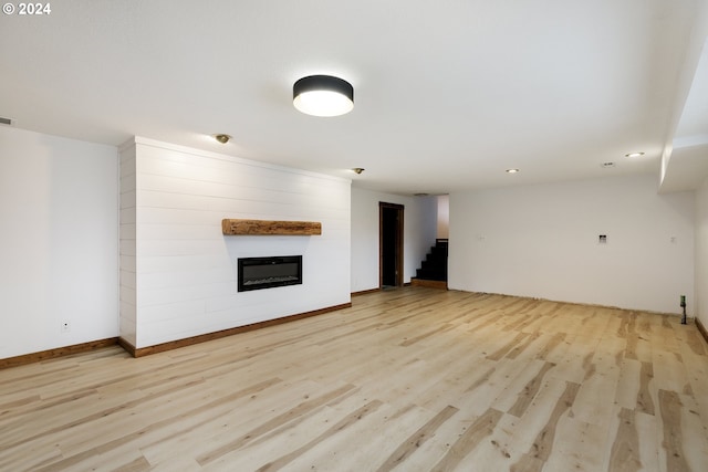 unfurnished living room featuring light wood-type flooring and a fireplace