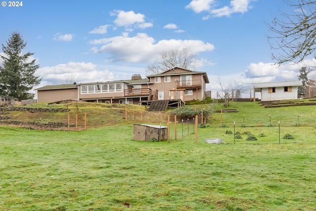 rear view of house with a lawn, a rural view, and a wooden deck