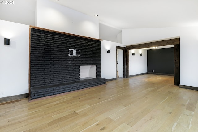 unfurnished living room with a fireplace, high vaulted ceiling, and light hardwood / wood-style floors